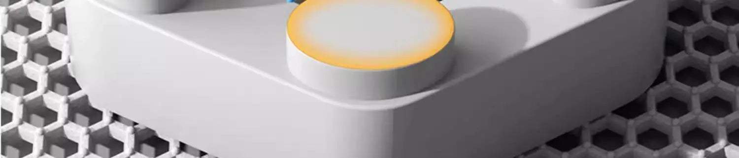 Close-up of a white electronic device with a yellow button on a honeycomb background