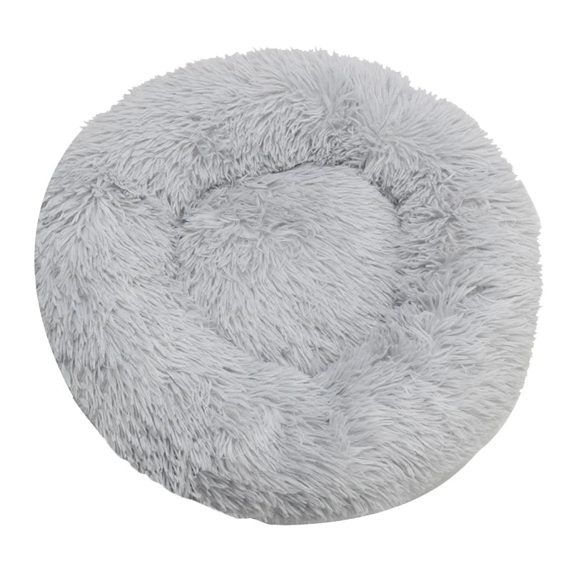 Round, fluffy gray pet bed on a white background